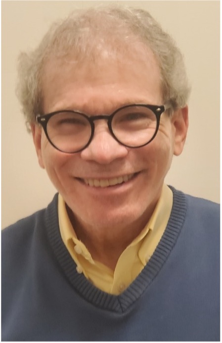 A picture of Dr. Hirsch, smiling at the camera. He wear black-rimmed glasses.